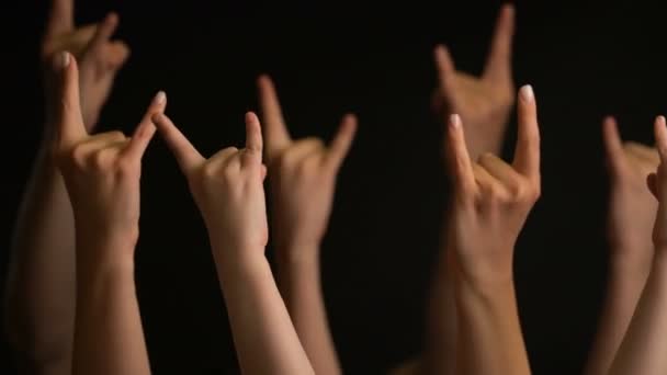 Ανύψωση χεριών με χειρονομία κατσίκας ή ροκ πινακίδα σε μαύρο φόντο. - Πλάνα, βίντεο