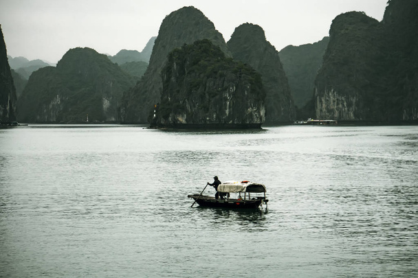 Visser in Ha Long Bay, visboot en huis vissers in prachtige landschap van Halong Bay, Vietnam - Foto, afbeelding