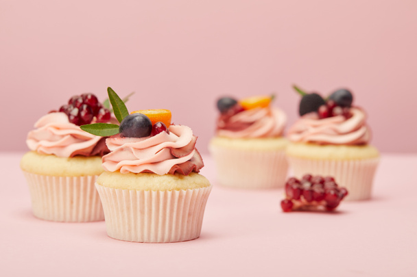 cupcake dolci con frutta e bacche sulla superficie rosa
 - Foto, immagini
