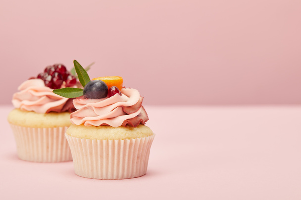 sweet cupcakes with fruits and berries on pink surface - Fotoğraf, Görsel