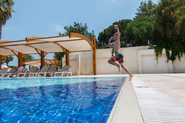 Хлопчик стрибає в басейн
 - Фото, зображення