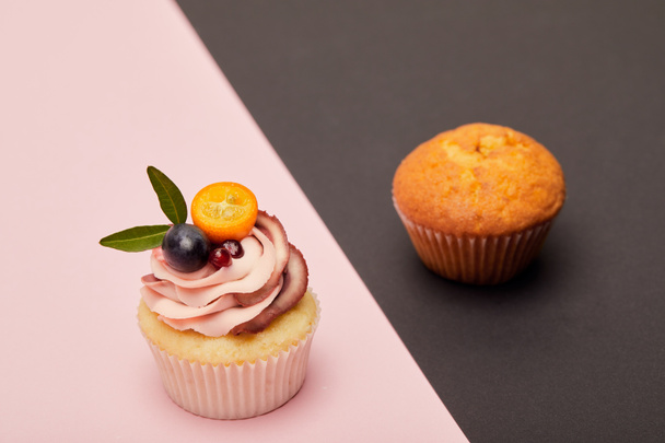 cupcake à la crème et gâteau sur surface rose et noire
 - Photo, image