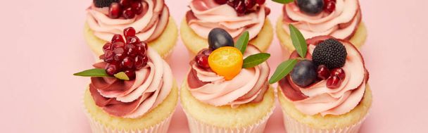 ピンクの表面にベリーや果物と甘いカップケーキのパノラマショット - 写真・画像