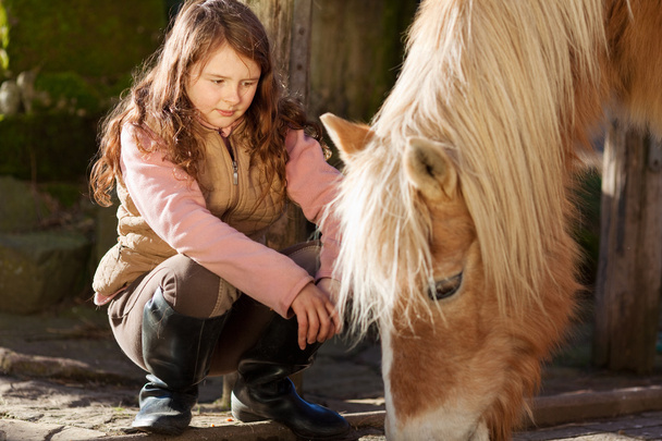 Girl observing a horse feeding - Photo, image