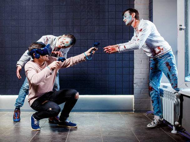Concept, a man playing video games about zombies, wearing virtual reality glasses. Grim zombies. - Foto, Imagen