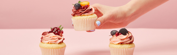 panoramic shot of woman with sweet cupcakes on pink - Foto, immagini