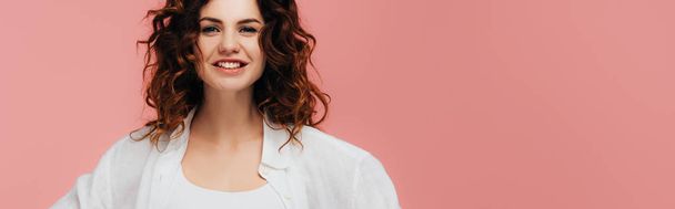 panoramic shot of happy curly girl looking at camera and smiling isolated on pink  - Fotografie, Obrázek