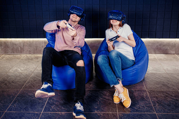 young guy and girl play in a virtual reality helmet  - Fotó, kép