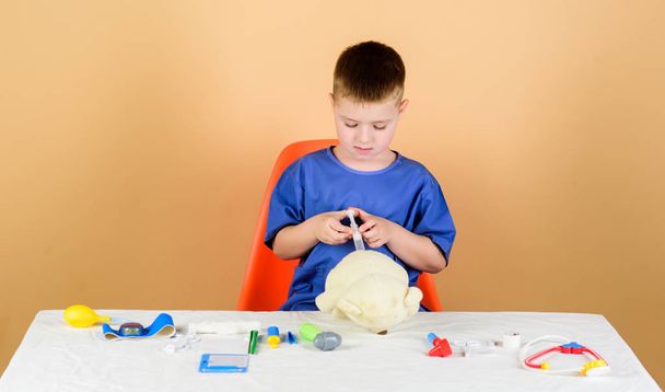 Medical procedures for teddy bear. Medical examination. Medical education. Boy cute child future doctor career. Health care. Kid little doctor busy sit table with medical tools. Medicine concept - Foto, Imagem