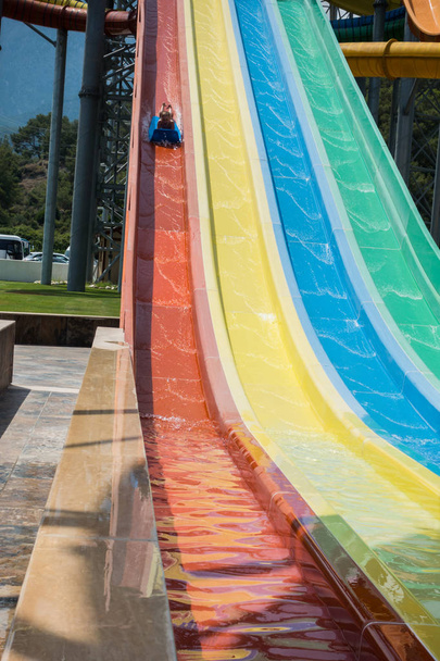 O menino monta um slide no parque aquático
 - Foto, Imagem