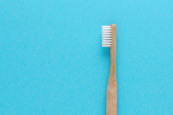 wooden toothbrush on blue background with copy space - Foto, Imagem