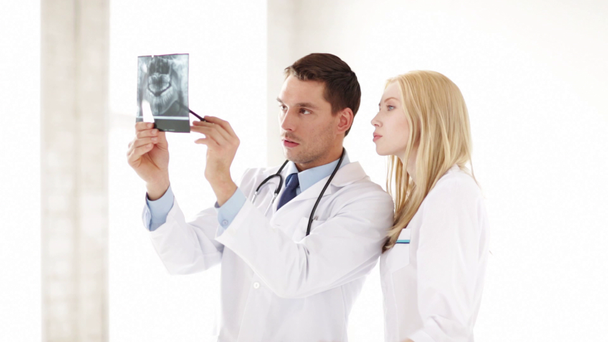 Closeup of two doctors with x-ray prints - Materiaali, video