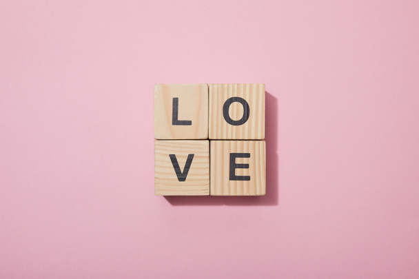 top view of wooden cubes with letters on pink surface - Фото, изображение