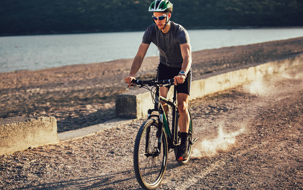 Ember lovagolni Mountain Bike a tengerparton. Sport és az aktív élet conce - Fotó, kép