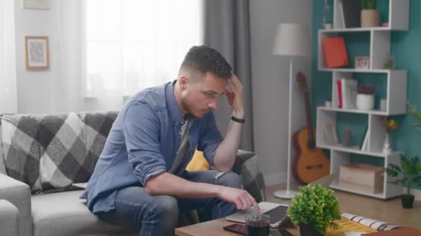 Sadness Unhappy Man Sitting at Sofa and Using Laptop - Footage, Video