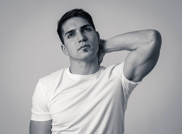 Young muscular fitness man touching and grabbing his neck and upper back suffering cervical pain isolated on neutral background. In sport injury Incorrect posture problems and body health care. - Valokuva, kuva