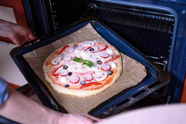 homemade italian pizza goes in the oven - Foto, Bild