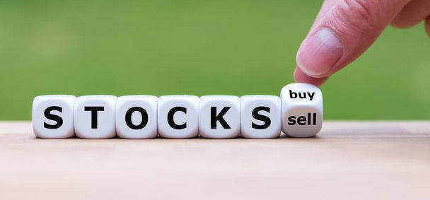 A részvények vásárlásának vagy eladásának szimbóluma. Kézzel fordul a kocka, és cserél - Fotó, kép