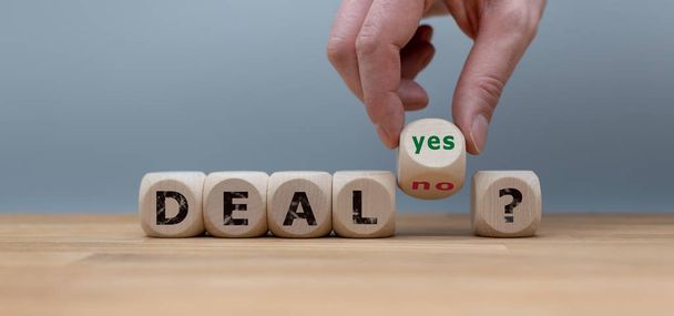 Deal of geen deal? Met de hand verandert u een kubus en wijzigt u het woord "nee"  - Foto, afbeelding