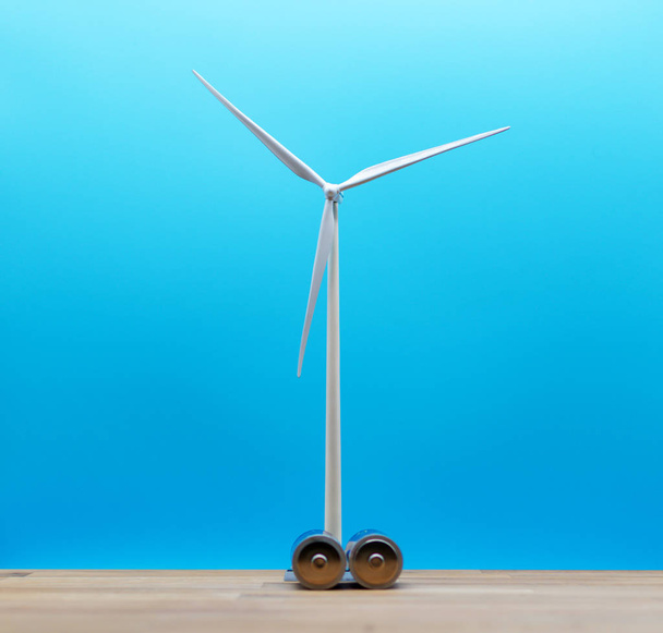 Symbol for saving wind energy. A model wind turbine in behind tw - Fotó, kép