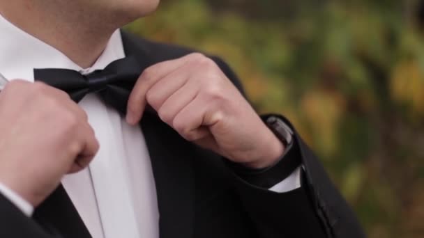 Nahaufnahme des Bräutigams im schwarzen Anzug draußen - Filmmaterial, Video