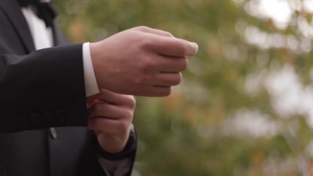 Hand eines Mannes im schwarzen Anzug draußen - Filmmaterial, Video