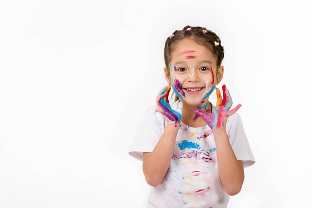 little child girl with hands painted in colorful paint - 写真・画像