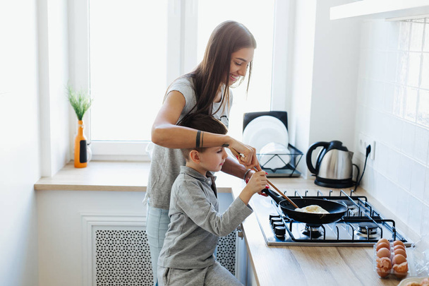 Mother and son preparing food in kitchen - Fotó, kép