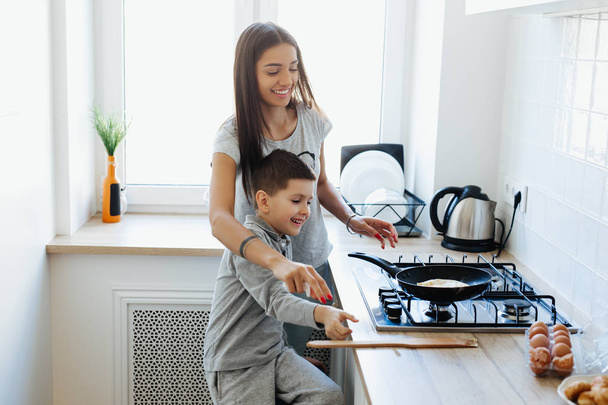 Happy family making breakfast in the kitchen - Фото, изображение