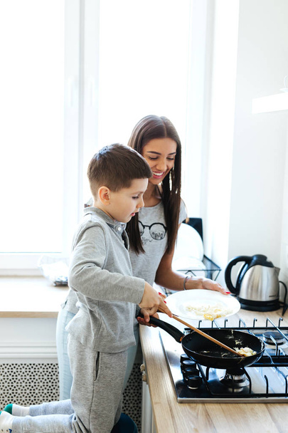 Mother and little son preparing food in kitchen - Foto, Imagem