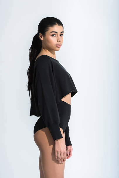 attractive african american girl in black sportswear looking at camera on white - Foto, imagen