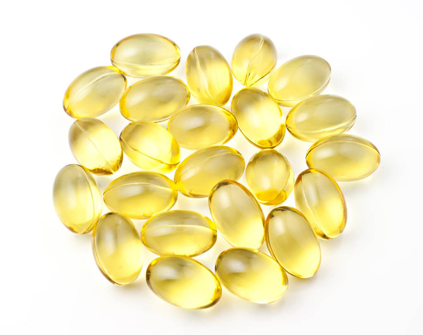Nutritional supplement pills in warm colors and shallow depth of field. The yellow ones are vitamin E and cod liver oil. - Photo, image