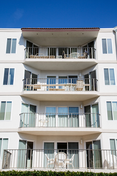 Quatro varandas de apartamento sob azul
 - Foto, Imagem
