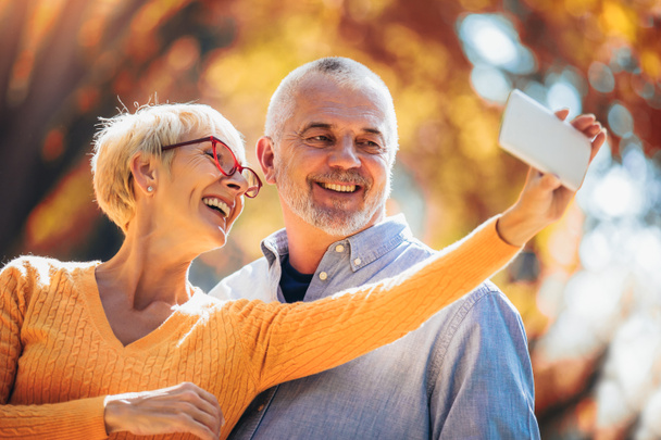 Ενεργοί ηλικιωμένοι που παίρνουν selfie των τους διασκεδάζουν έξω στο  - Φωτογραφία, εικόνα
