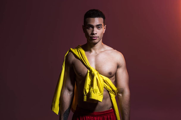 handsome mixed race man with muscular torso looking at camera on dark background - Valokuva, kuva