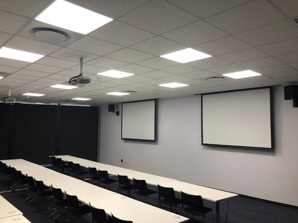 Порожня навчальна кімната з проектором та екранами для презентації
. - Фото, зображення