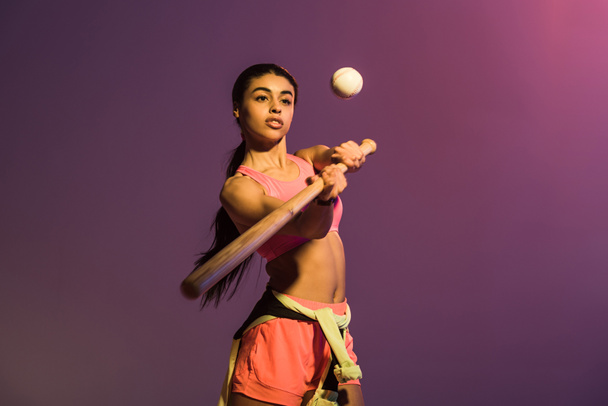 attractive sportive african american girl playing baseball on purple background - Fotografie, Obrázek