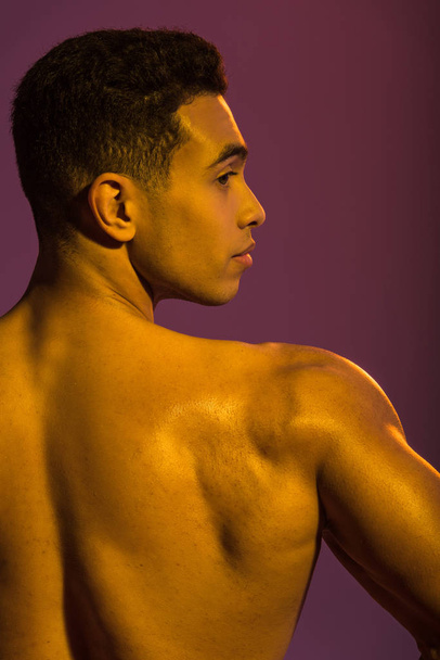 guapo deportivo mestizo hombre de raza con torso muscular sobre fondo púrpura
 - Foto, Imagen