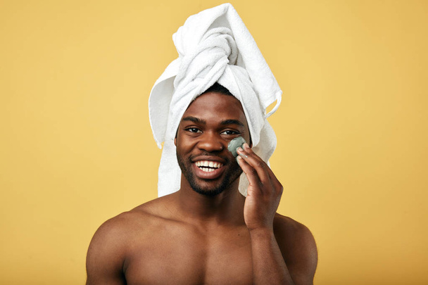 happy black good looking guy massaging his face - Photo, Image