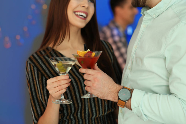 Young couple with martini cocktails at party, closeup - Фото, изображение