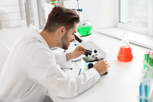 Medical student working with microscope in modern scientific laboratory - Φωτογραφία, εικόνα