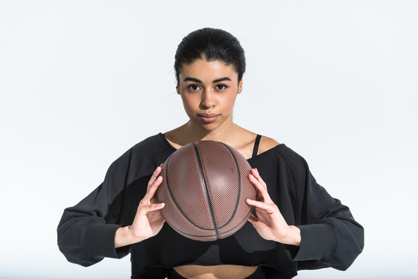 gyönyörű sportos afro-amerikai lány, barna labdát nézett kamera fehér - Fotó, kép