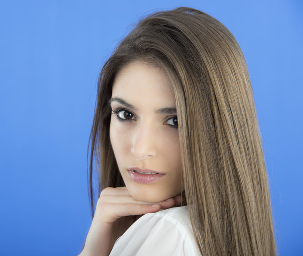Young Woman with long Hair on blue background - Фото, изображение