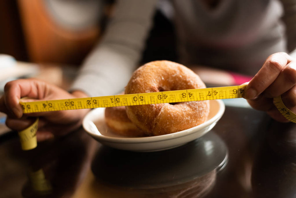 terzi ölçüm bandı ile donut - Fotoğraf, Görsel