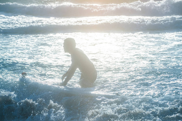 Young man, beginner Surfer learns to surf on a sea foam on the Crete island, beach Falasarna - Φωτογραφία, εικόνα