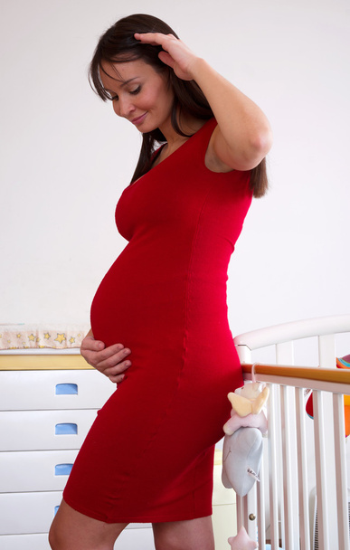terhes nő közelében kiságy - Fotó, kép