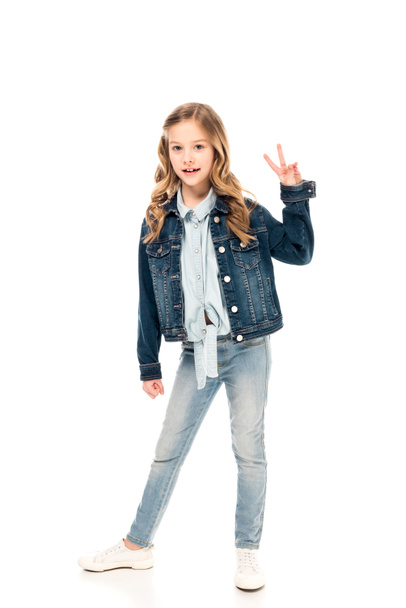 full length view of kid in jeans showing peace sign on white - Foto, immagini
