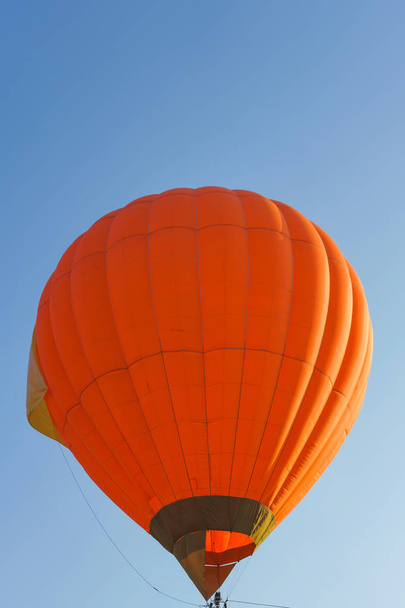 Orange color hot air balloon on blue sky background. Hot Air Balloons on Balloon Festival. Balloon Festival in Kazakhstan. Flying on balloons in the daytime. - Fotó, kép