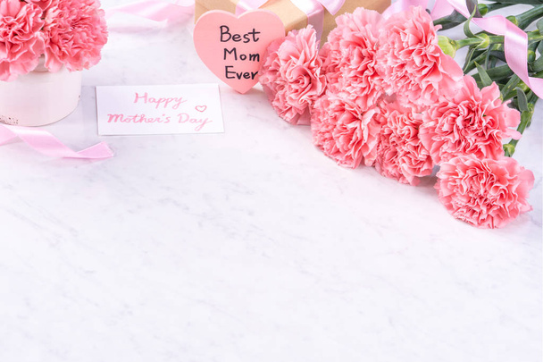 Design concept - Beautiful bunch of carnations on marble white background, top view, copy space, close up, mock up. Mothers day gift idea inspiration. - Фото, изображение