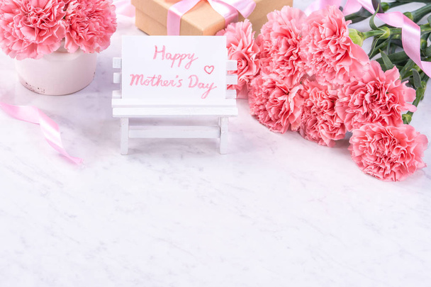 Design concept - Beautiful bunch of carnations on marble white background, top view, copy space, close up, mock up. Mothers day gift idea inspiration. - Photo, image